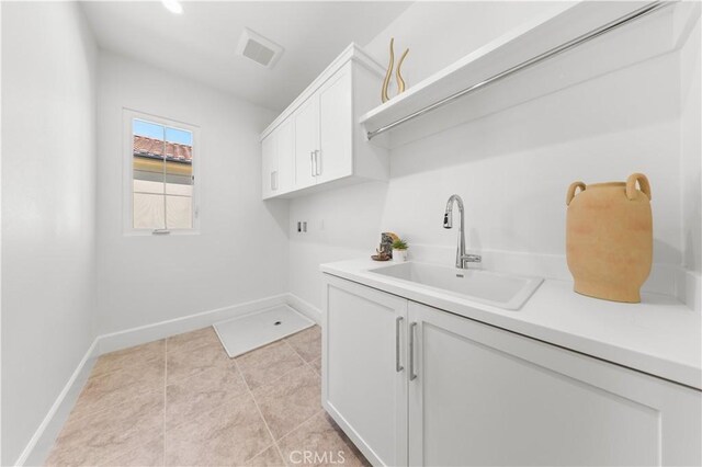 122 Appian Blvd, Irvine, CA 92602 - laundry room with visible vents, a sink, light tile patterned flooring, baseboards, and cabinet space
