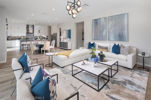 living room featuring light wood-type flooring and an inviting chandelier