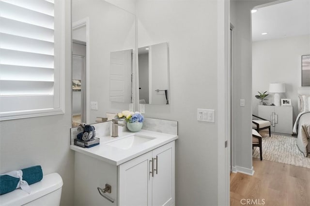 bathroom with hardwood / wood-style floors, toilet, and vanity