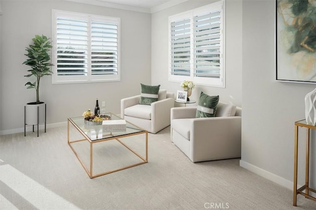 sitting room with crown molding and light colored carpet