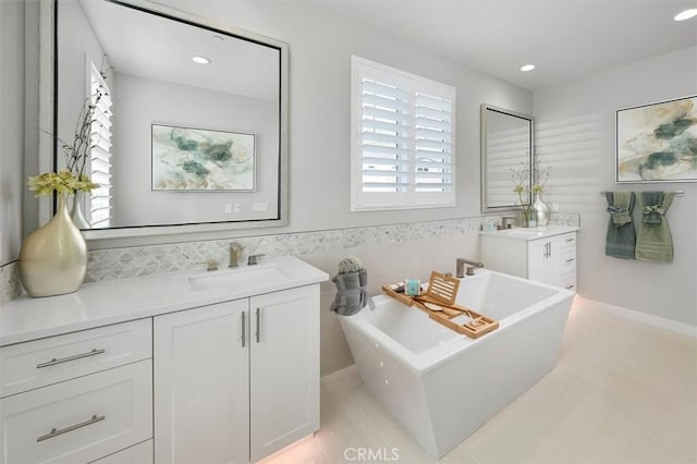 bathroom featuring tile walls, a tub, vanity, and tile patterned floors