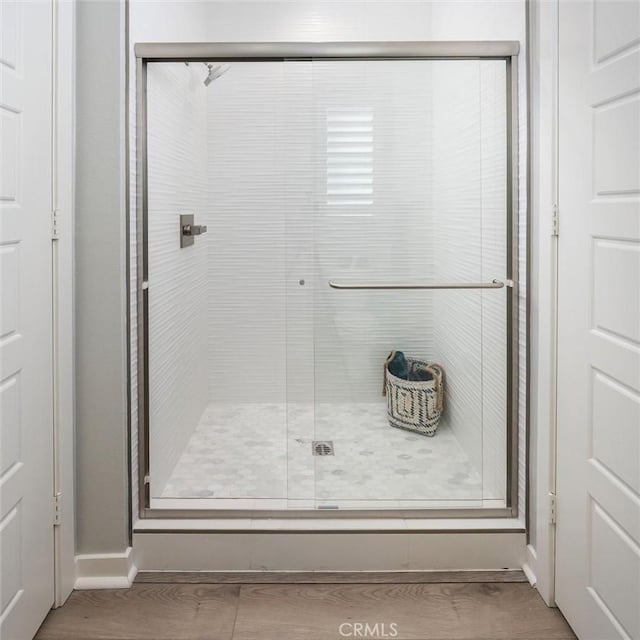 bathroom with hardwood / wood-style flooring and walk in shower