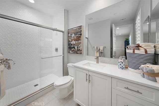 bathroom with toilet, tile patterned flooring, vanity, and a shower with door