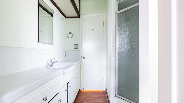 bathroom with hardwood / wood-style flooring, an enclosed shower, and vanity