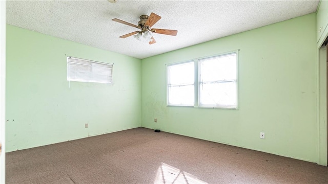 carpeted empty room with a textured ceiling and ceiling fan