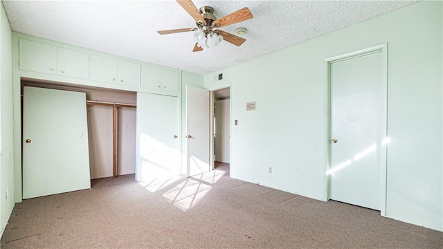 unfurnished bedroom with a textured ceiling, ceiling fan, a closet, and light colored carpet