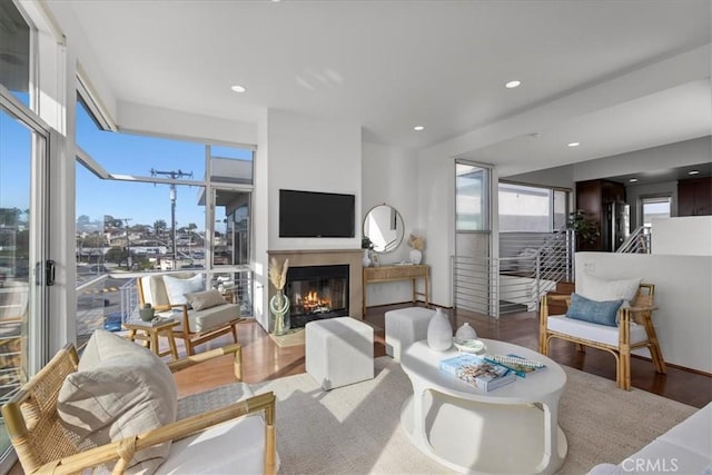 living room with a fireplace with flush hearth, recessed lighting, and wood finished floors