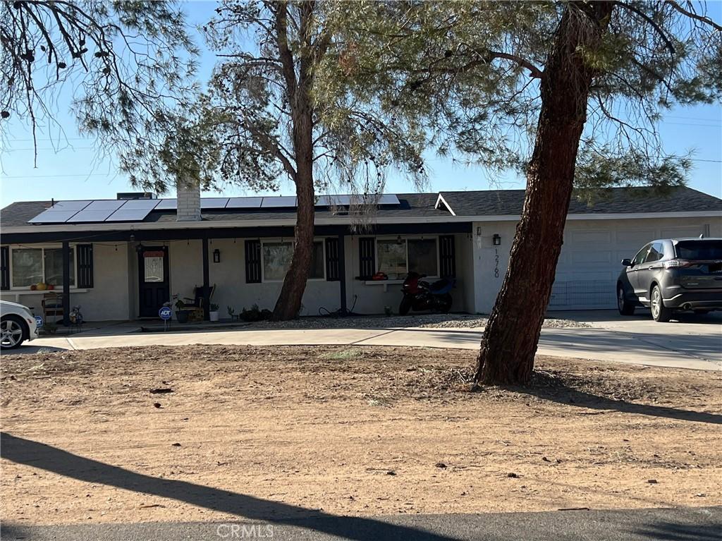 ranch-style home featuring a garage and solar panels