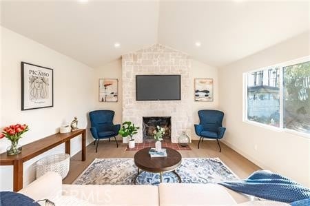 living area featuring lofted ceiling and a brick fireplace