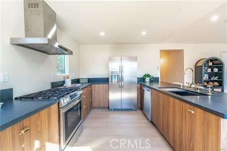 kitchen featuring sink, kitchen peninsula, wall chimney range hood, and stainless steel appliances