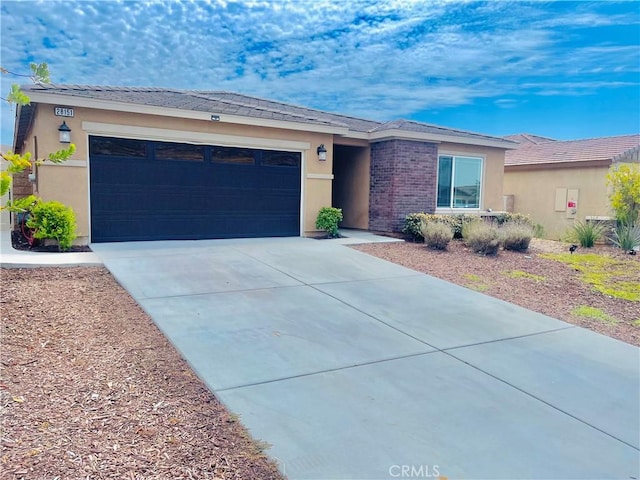 ranch-style home featuring a garage, brick siding, driveway, and stucco siding