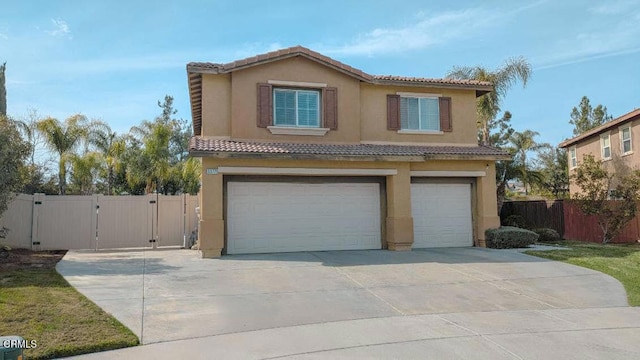 view of front of home with a gate, fence, an attached garage, and stucco siding