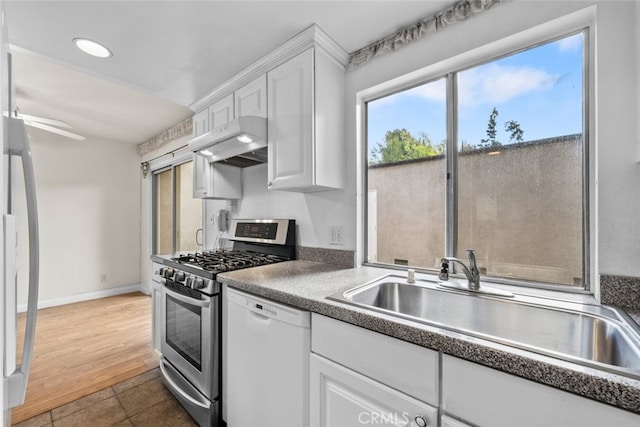 kitchen featuring sink, stainless steel appliances, and white cabinetry