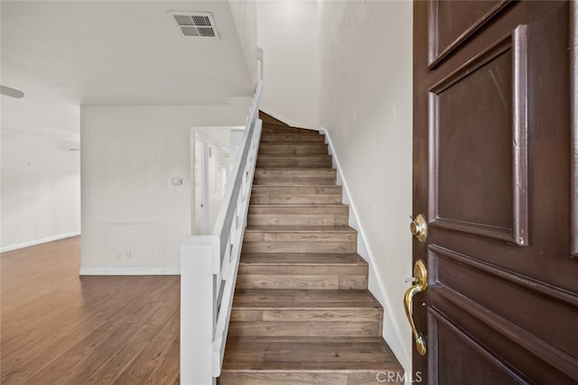 staircase with hardwood / wood-style flooring