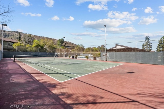 view of tennis court featuring a mountain view