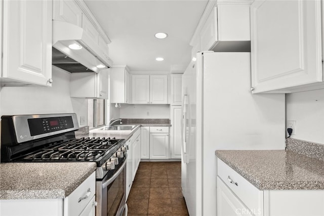 kitchen featuring white cabinetry, gas range, white refrigerator, and premium range hood