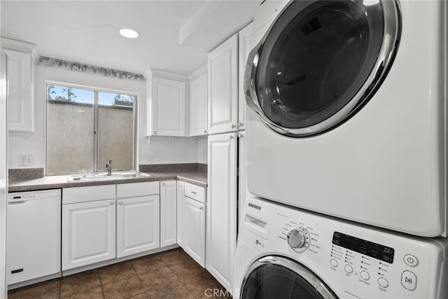 laundry room featuring sink and stacked washer / dryer