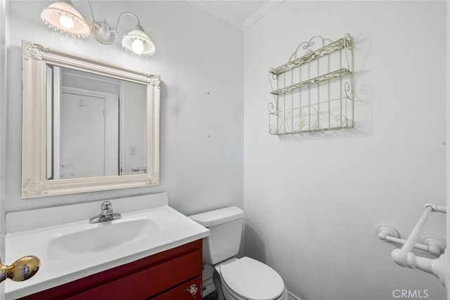 bathroom featuring toilet, vanity, and ornamental molding