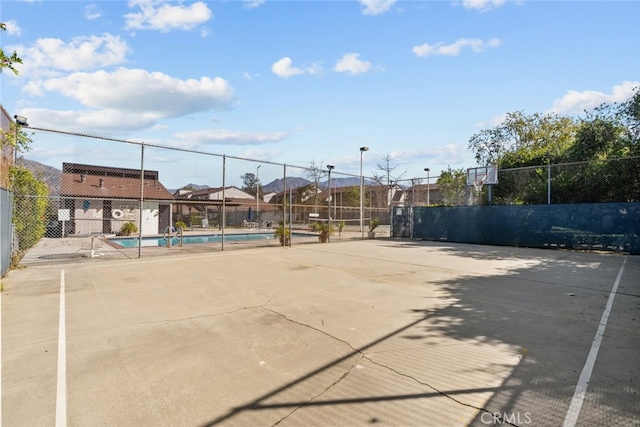 view of tennis court featuring a community pool