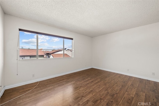 unfurnished room with a textured ceiling and dark hardwood / wood-style floors