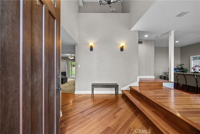 foyer featuring wood-type flooring and a towering ceiling