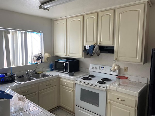 kitchen with a sink, cream cabinets, white electric stove, tile countertops, and extractor fan