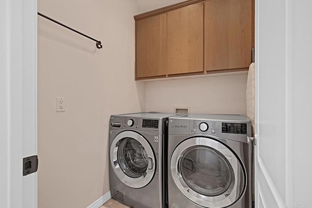 clothes washing area with independent washer and dryer and cabinets