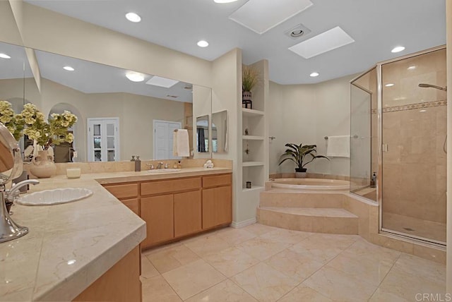 bathroom featuring shower with separate bathtub, built in shelves, a skylight, and vanity