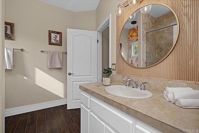 bathroom with hardwood / wood-style flooring, a shower, and vanity