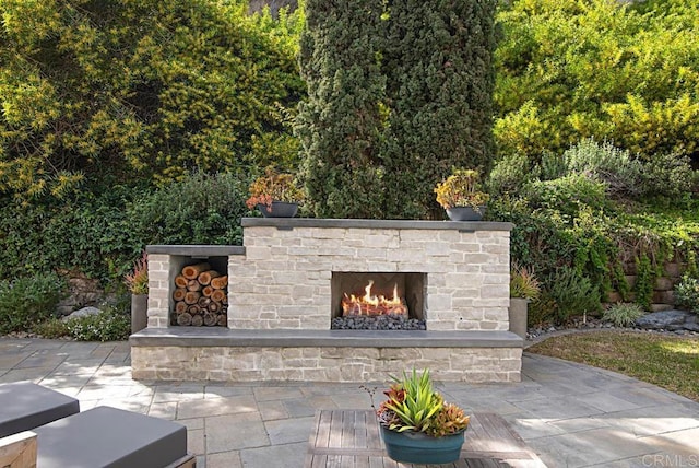 view of patio featuring an outdoor stone fireplace