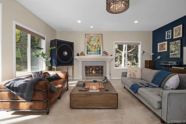 carpeted living room featuring a healthy amount of sunlight and a chandelier