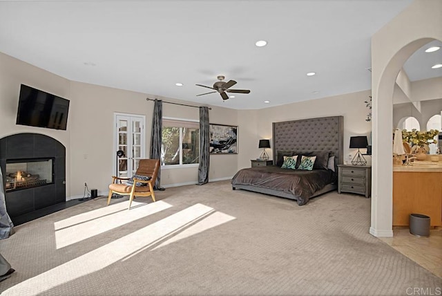 carpeted bedroom with sink, ceiling fan, and a tile fireplace