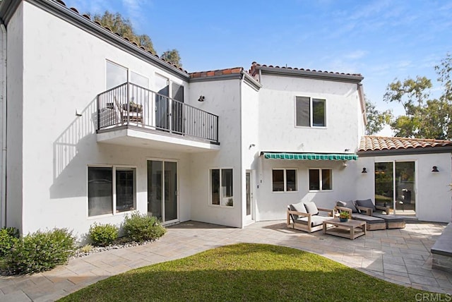 rear view of property with a lawn, a patio area, a balcony, and an outdoor hangout area