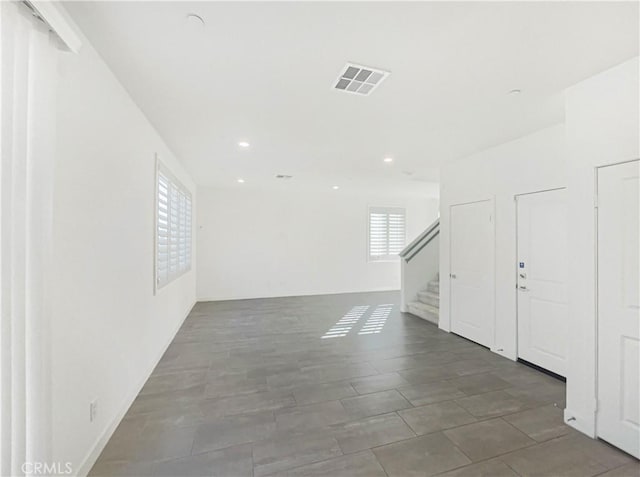 unfurnished room featuring stairs, visible vents, and recessed lighting