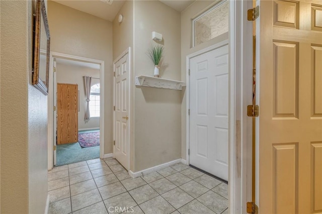 foyer featuring baseboards and light tile patterned flooring