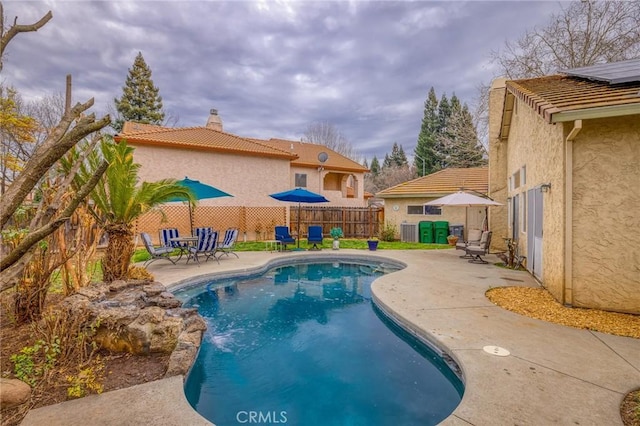 view of pool featuring a patio area, central air condition unit, a fenced in pool, and fence