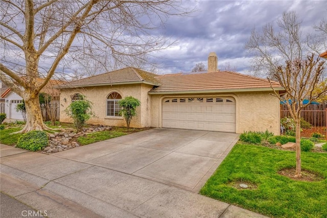 view of front of property with stucco siding, driveway, fence, an attached garage, and a chimney