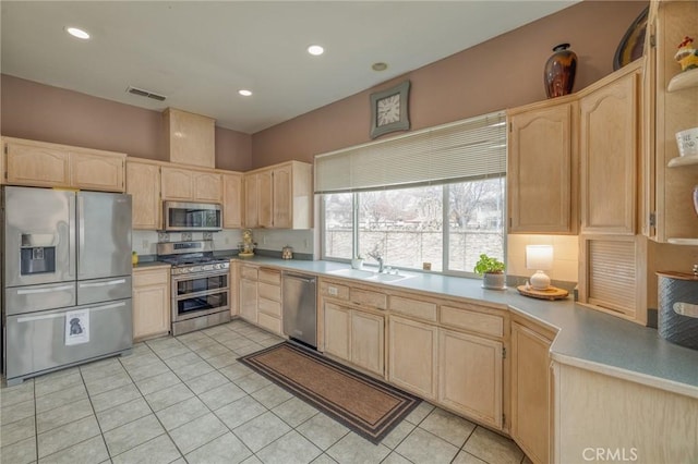 kitchen featuring visible vents, light brown cabinets, light tile patterned floors, appliances with stainless steel finishes, and a sink