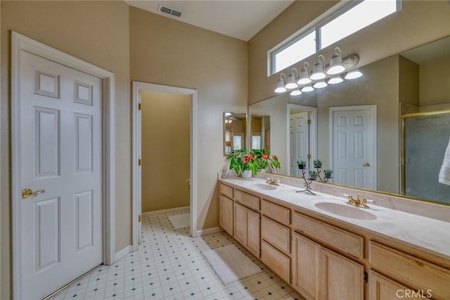 bathroom featuring a sink, visible vents, double vanity, and a shower stall