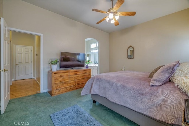 bedroom featuring arched walkways, a ceiling fan, carpet flooring, and vaulted ceiling