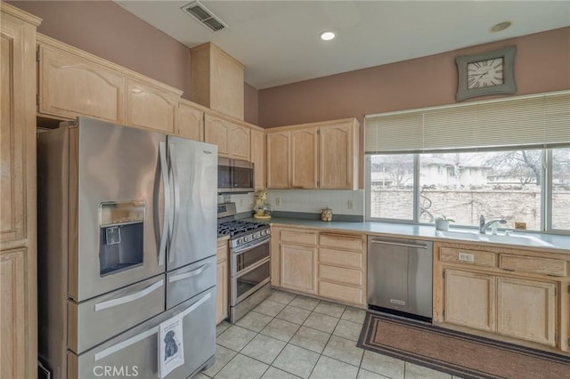 kitchen featuring a sink, a healthy amount of sunlight, light brown cabinetry, and stainless steel appliances