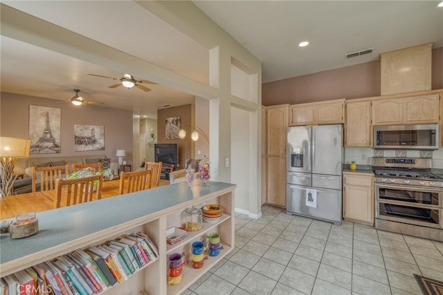 kitchen featuring visible vents, light brown cabinetry, stainless steel appliances, light tile patterned floors, and decorative backsplash