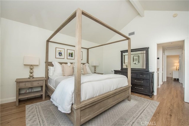 bedroom featuring beamed ceiling, light hardwood / wood-style floors, and high vaulted ceiling