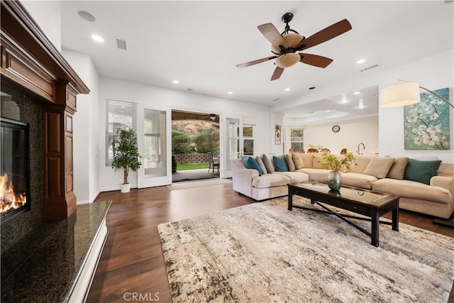 living area with a high end fireplace, visible vents, dark wood finished floors, and recessed lighting