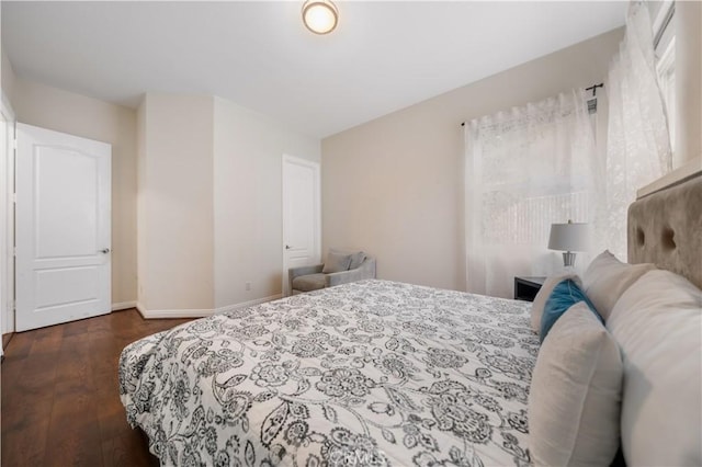 bedroom with baseboards and dark wood-type flooring