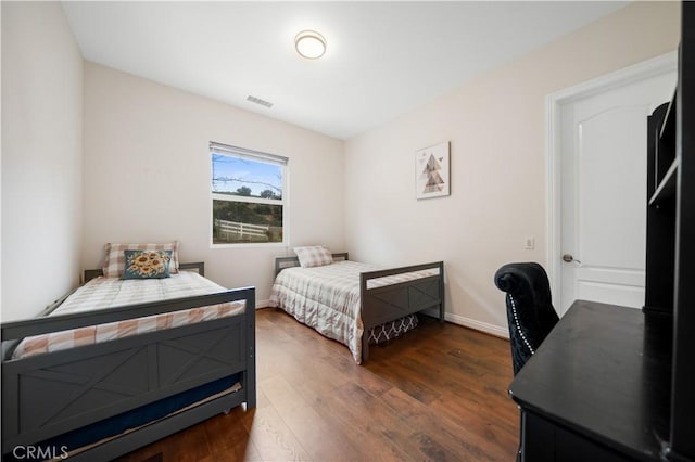 bedroom featuring dark wood-style flooring, visible vents, and baseboards