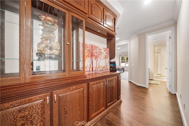 corridor featuring baseboards, dark wood finished floors, and crown molding