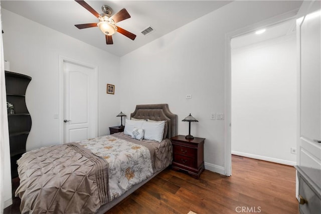 bedroom with dark wood-type flooring, visible vents, ceiling fan, and baseboards