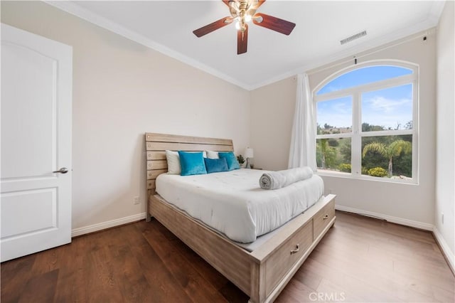 bedroom featuring dark wood-style flooring, visible vents, crown molding, and baseboards