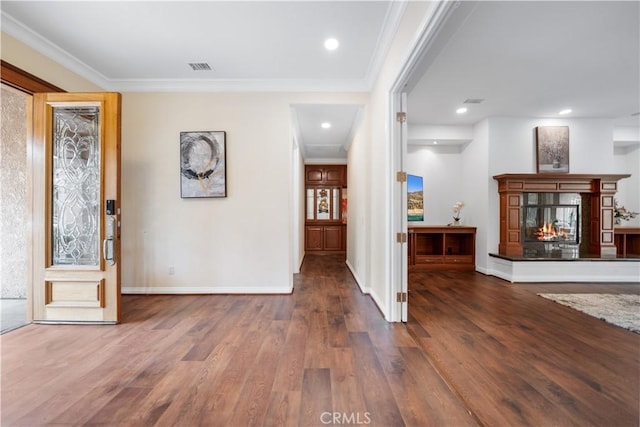 entrance foyer with ornamental molding, a multi sided fireplace, dark wood finished floors, and baseboards